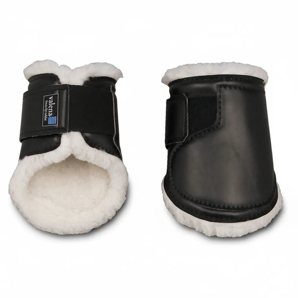 Toklat Valena Horse Ankle Boots in black, size medium (11.5" x 6.75"). This hind pair features a durable heavy-duty vinyl exterior and plush white WoolBack fleece lining for superior comfort and impact protection. Designed with a secure hook-and-loop closure and the signature Valena logo, these equestrian boots prevent rubs and injuries. Ideal for horse owners seeking high-quality, fleece-lined hind leg protection for training and performance.