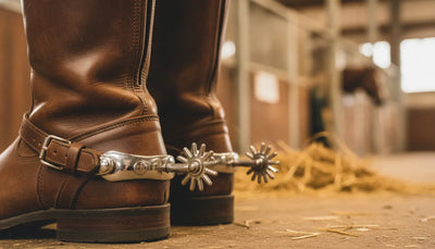 Close-up of equestrian boots with silver horse spurs attached at the heel