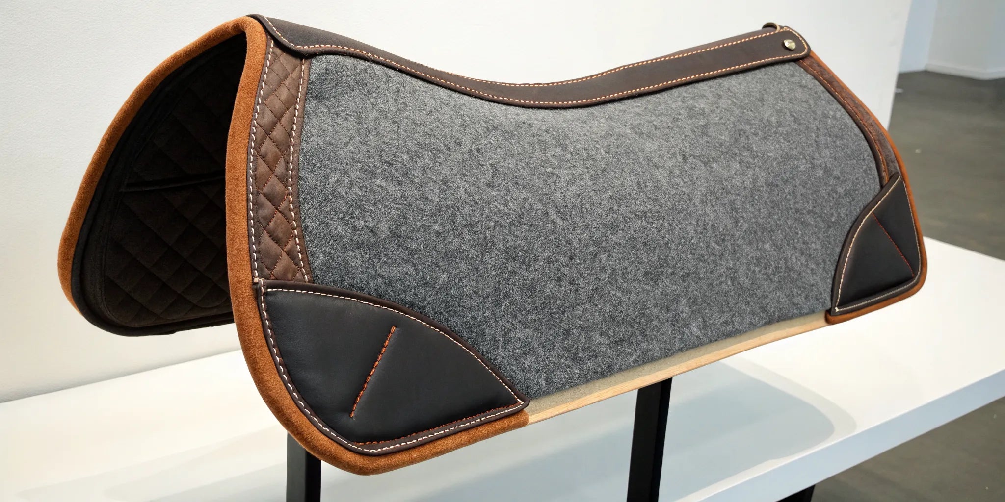 A CSI saddle pad with grey felt and leather trim, the focus of a saddle pads review.