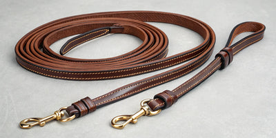 Custom leather roping reins with brass hardware and detailed stitching.