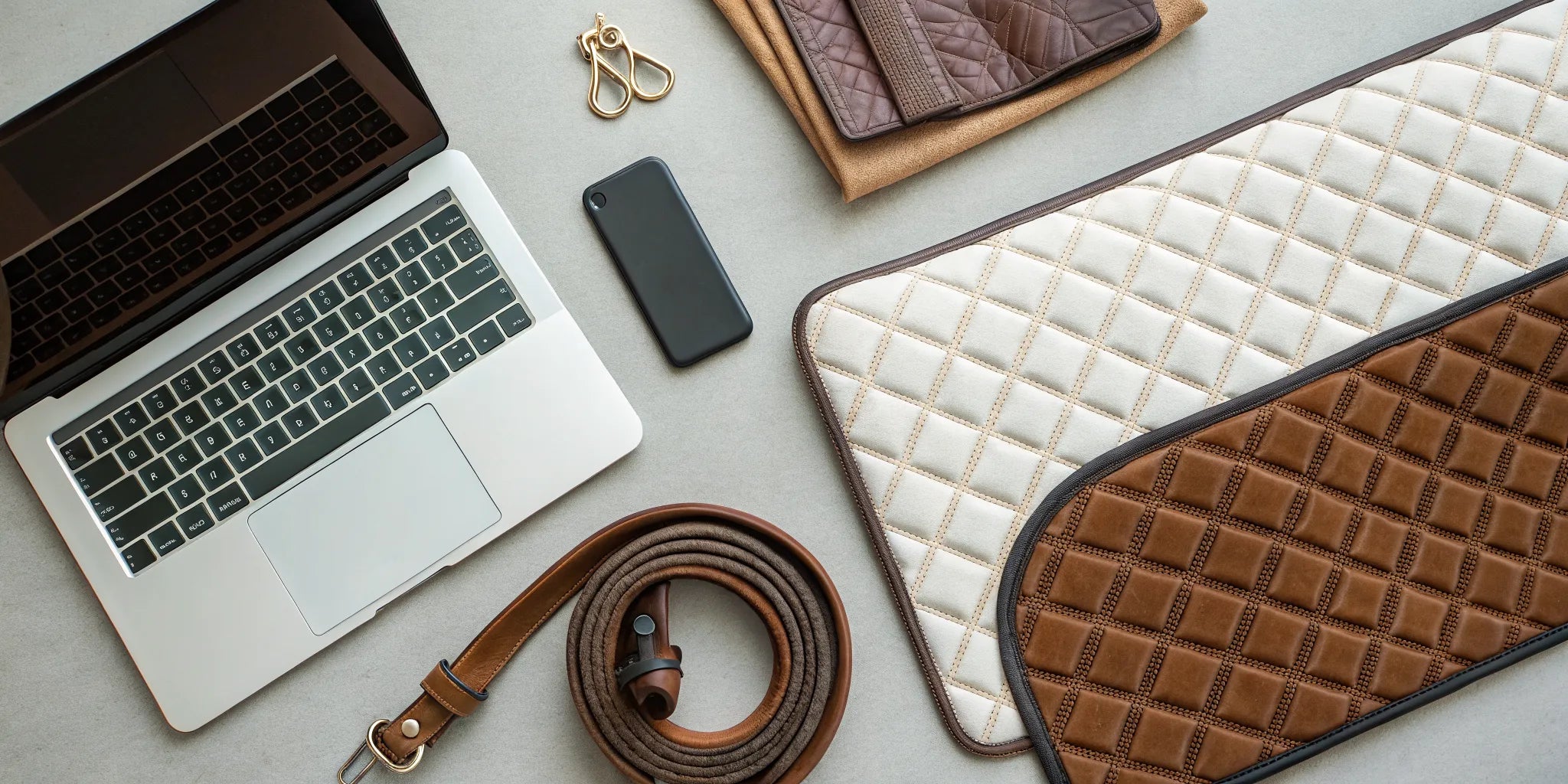 Western saddle pads and a laptop on a desk for buying the right pad online.