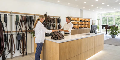 Saddles and bridles on display in a horse tack shop with an easy returns policy.