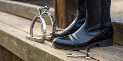 English spurs correctly fitted on the heel of a pair of riding boots.