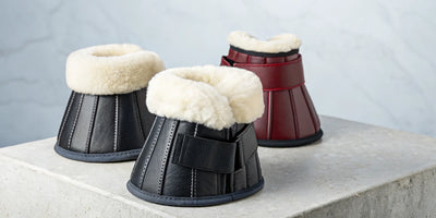 A pair of black and burgundy over reach boots with a soft sheepskin lining.