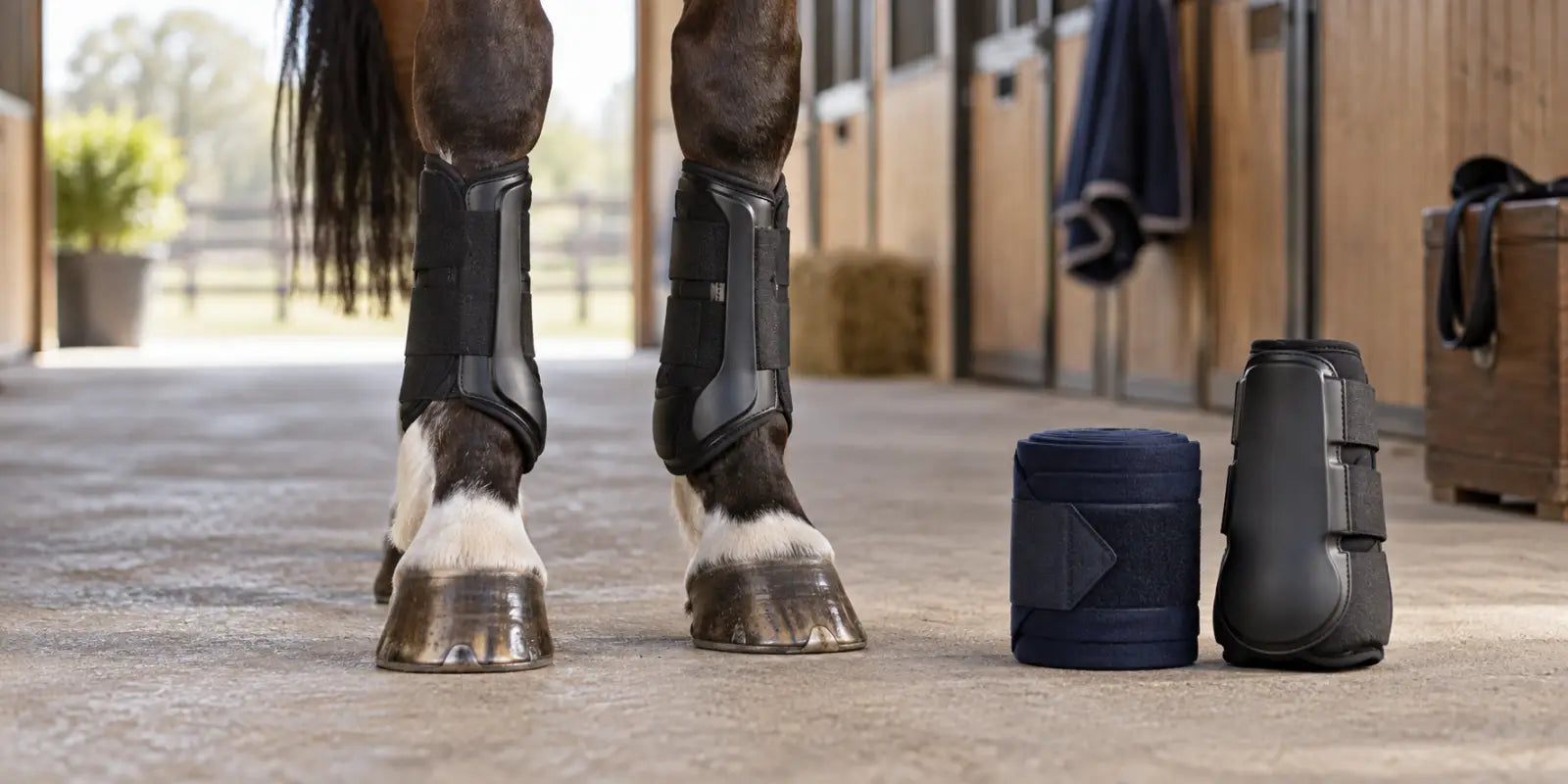 Horse wearing fitted protective leg boots, with polo wraps and a splint boot nearby