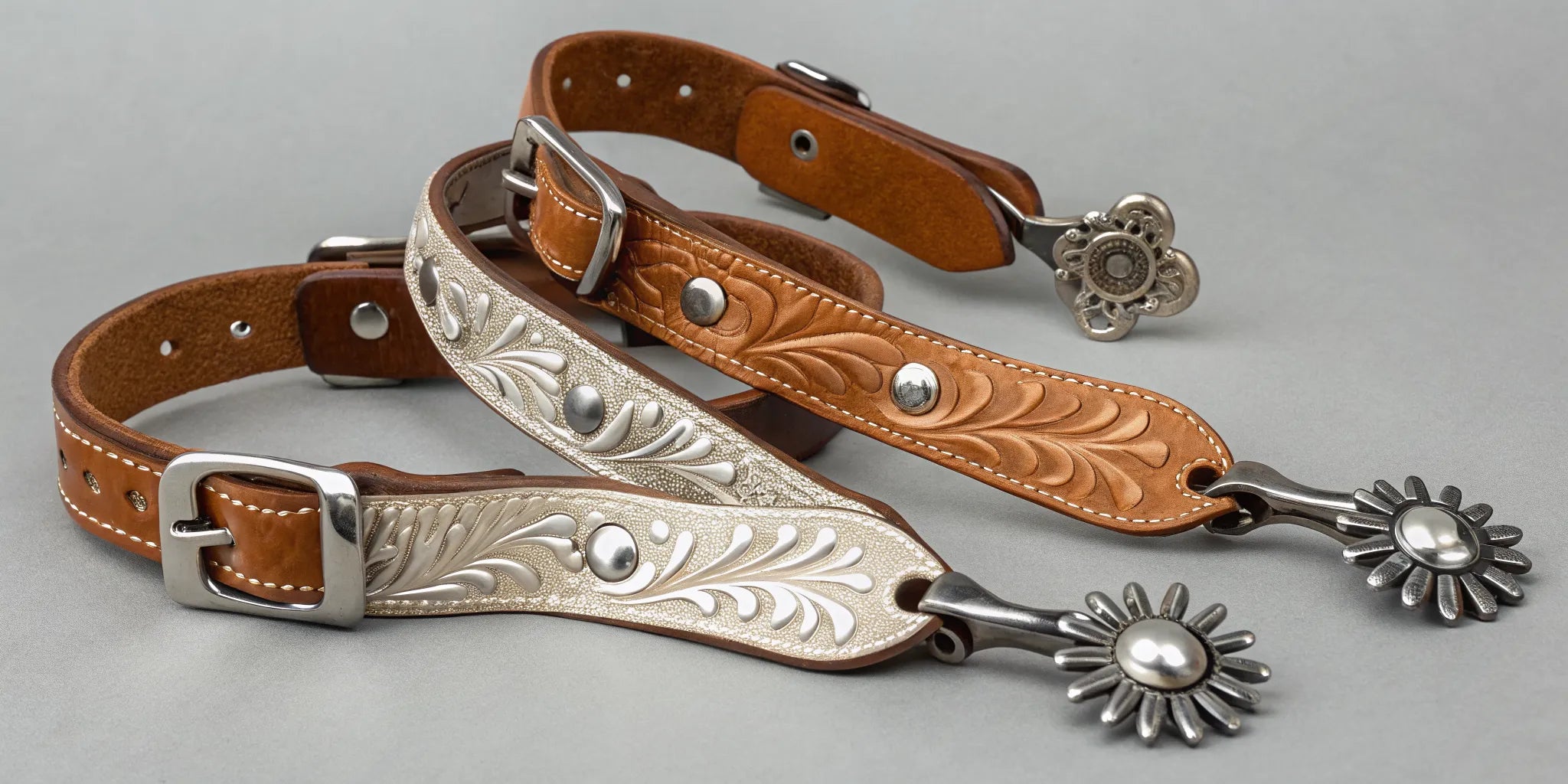 A pair of Western spurs with decorative tooled leather straps.