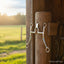 Myler MB 29 Sweet Iron horse bit with cathedral port and stainless steel shanks, offering ultimate horse comfort, hanging on a rustic wooden post in a sunlit equestrian setting.