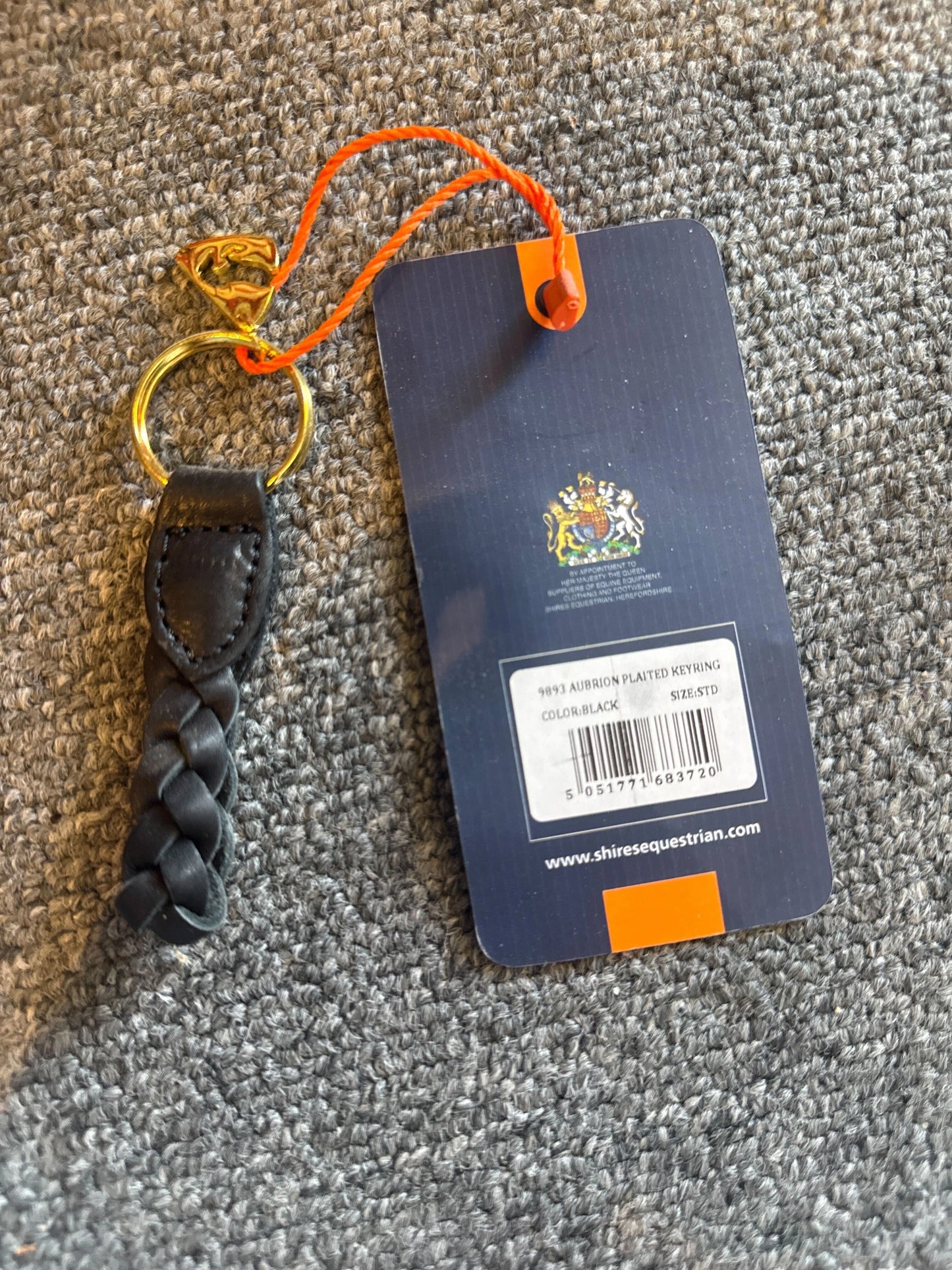 Keychain with braided design and Shires Equestrian branded tag on a textured surface