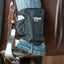 Black leather pouch with a brand logo attached to a horse's saddle