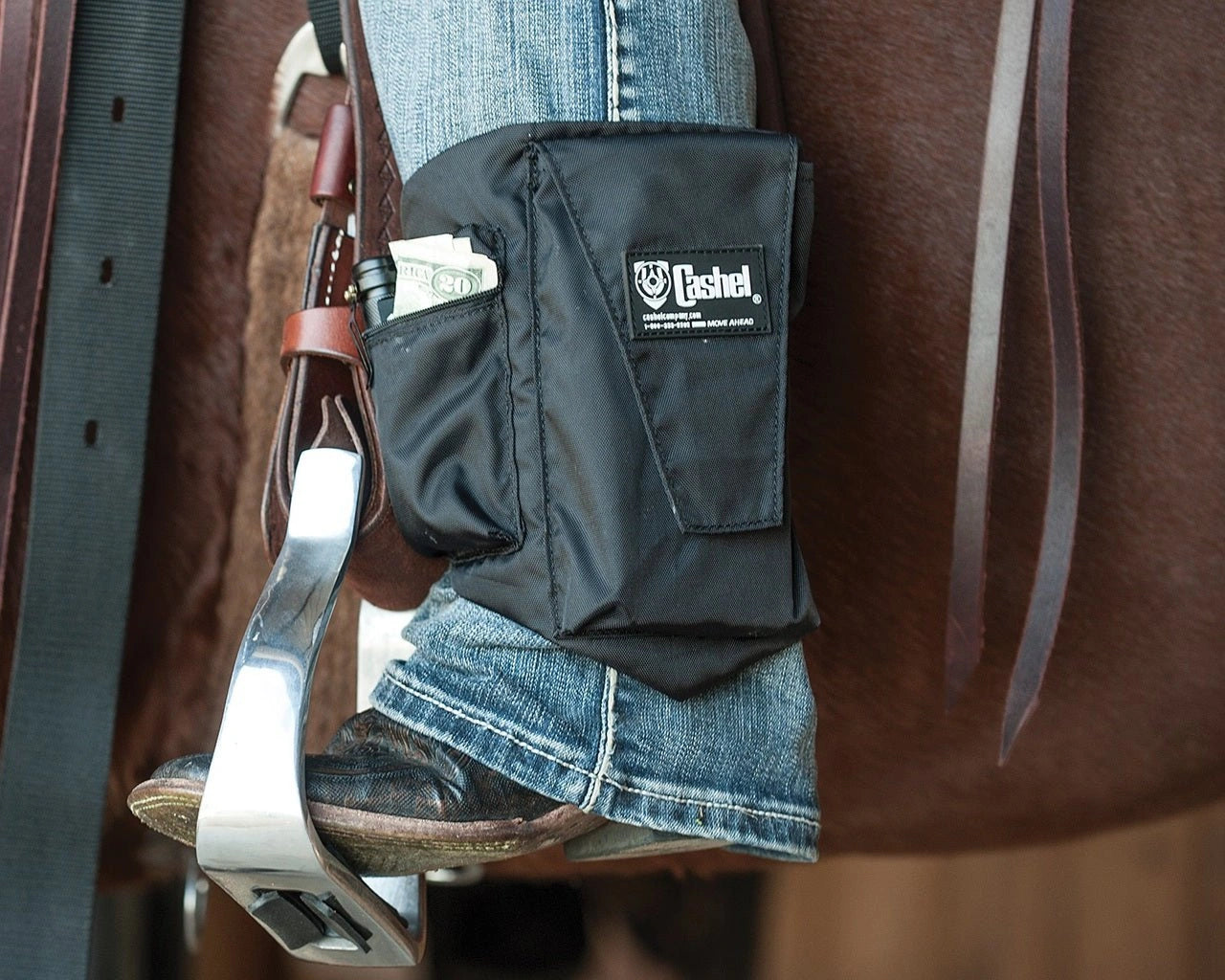 Black leather pouch with a brand logo attached to a horse's saddle