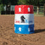 Classic Equine Barrel Cover featuring a patriotic red, white, and blue three-stripe design with the brand’s signature horse head logo. This durable equestrian training accessory is shown positioned in a dirt riding arena, ideal for barrel racing practice and professional competitions. Perfect for horse trainers and barrel racers looking for high-visibility, professional-grade barrel wraps to enhance their western arena setup.