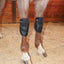Classic Equine MagNTX black mesh knee wraps providing magnetic therapy for horse joint health. The contoured boots are shown securely fastened on a horse’s front legs in a stall with wood shavings. Ideal for equine recovery, reducing inflammation, and maintaining joint mobility in performance horses. High-quality equine therapy gear for injury prevention and senior horse care.