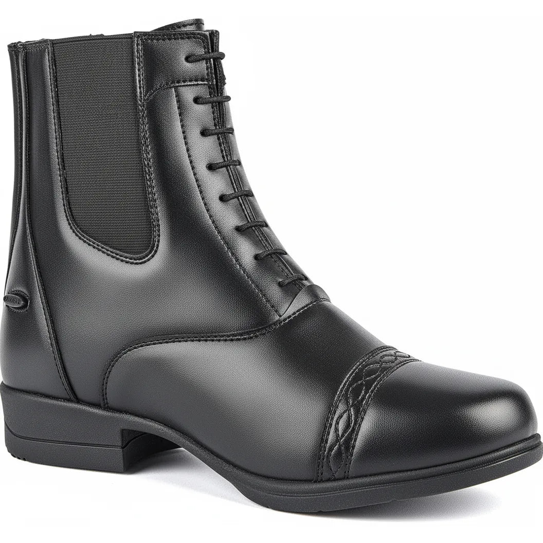 Shires Moretta Anita Women's Synthetic Leather Paddock Riding Boots in classic black. These equestrian boots feature a sophisticated mock lace front, decorative toe cap detail, and flexible elastic side panels for comfort. Crafted from durable synthetic leather with a WickAway moisture-wicking lining and convenient rear zipper. Ideal for horse riding and stable chores, these stylish ankle boots offer a traditional look with modern, easy-care materials.
