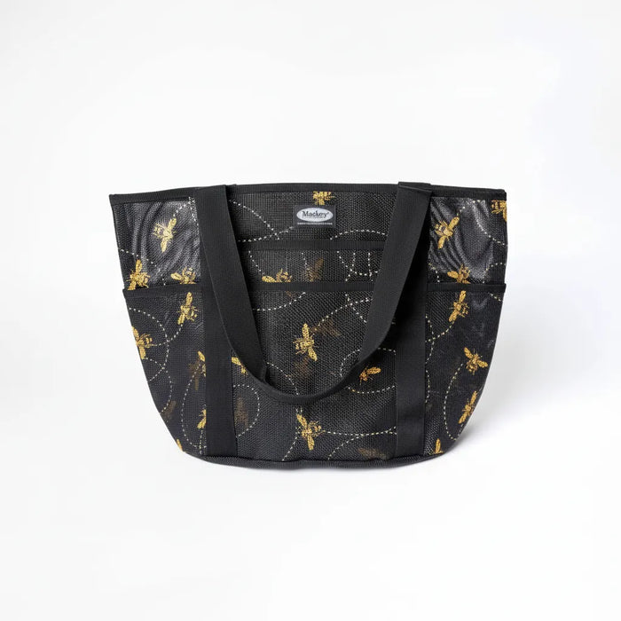 Mackey, Inc. Personal Tote Bag in heavy-duty black PVC mesh featuring a gold honeybee pattern with dotted flight paths. This durable equestrian shoulder bag includes an 8.5-inch handle drop, multiple exterior pockets for organization, and a spacious 19.25 x 12.75-inch design. Perfect as a stylish horse grooming tote, beach bag, or everyday carryall, this breathable mesh bag combines functional strength with a whimsical bee print.