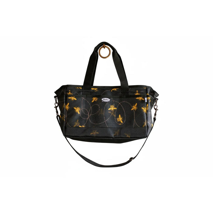 Mackey Equine Organizer Tote in black PVC mesh featuring a charming yellow honeybee print and flight trail details. This 16x10x8 grooming bag includes dual top handles, an adjustable shoulder strap, and multiple external pockets for stable organization. The breathable, hose-clean mesh design is perfect for storing horse brushes and tools. Ideal for barn use or travel, this durable horse gear bag offers both style and functionality for equestrians.