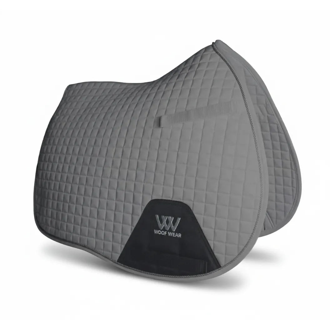 Toklat All-Purpose English Horse Saddle Pad in a sleek grey. This anatomical GP riding pad features a classic small-diamond quilted design, a contoured topline for wither clearance, and a durable black reinforcement patch with the Woof Wear logo to prevent girth rub. Designed for comfort and durability, this equestrian essential is perfect for schooling or competition, offering a professional look and high-performance fit for your horse.