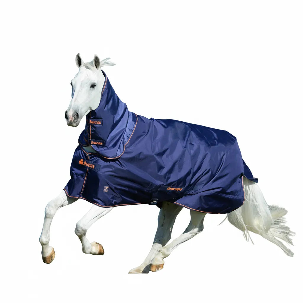 Toklat Bucas Therapy Turnout Horse Blanket in navy blue with orange trim, featuring a 150g fill and silky lining. A white horse gallops while wearing this full-neck turnout rug, showcasing its ergonomic fit and therapeutic technology. Ideal for cold weather protection and muscle recovery, this durable equestrian blanket provides superior comfort and style for horses in the paddock.