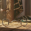 Myler 33 Eggbutt with Hooks horse bit resting on a rustic wooden barn floor with scattered hay. Sunlight streams from a window, highlighting a bridle and horse blanket in the background.