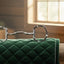 Myler 04 Stainless Steel Eggbutt with Hooks horse bit resting on a green quilted saddle pad in a rustic, sunlit barn with hay bales.
