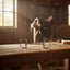 Myler MB 09 Dee Snaffle Bit, stainless steel with copper inlay, on a rustic wooden table in a sunlit equestrian stable.