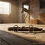 Myler Eggbutt Snaffle bit with stainless steel ported barrel and copper inlay, lying on a brown leather strap on a sunlit barn floor with a horse in the background.