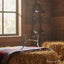 Myler MB 36 sweet iron ported barrel horse bit displayed on a patterned blanket over hay bales in a rustic barn, with a leather bridle and sunlit window in the background, for enhanced horse comfort.