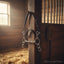 Myler MB 01 Combination horse bit with sweet iron comfort snaffle and 6-inch shanks, hanging on a wooden stable post bathed in sunlight.