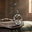 Silver Myler Western 2 Hook Low Port Comfort Snaffle bit on a dark brown leather western saddle with a plaid blanket in a rustic, sunlit barn.