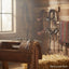 Myler MB 47 Correctional Curb Bit (sweet iron, 5 inch mouth) on a rustic wooden saddle stand in a barn, with hay bales and horse tack in the background.