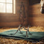 Myler MB 47PB Sweet Iron Correctional Ported Barrel horse bit on a green towel in a sunlit stable with a horse in the background.
