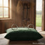 Silver Myler MB 36 Loose Ring Snaffle dressage bit on a dark green velvet pillow in a sunlit stable setting.