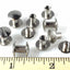 Metal rivets on a white background with a ruler for scale.