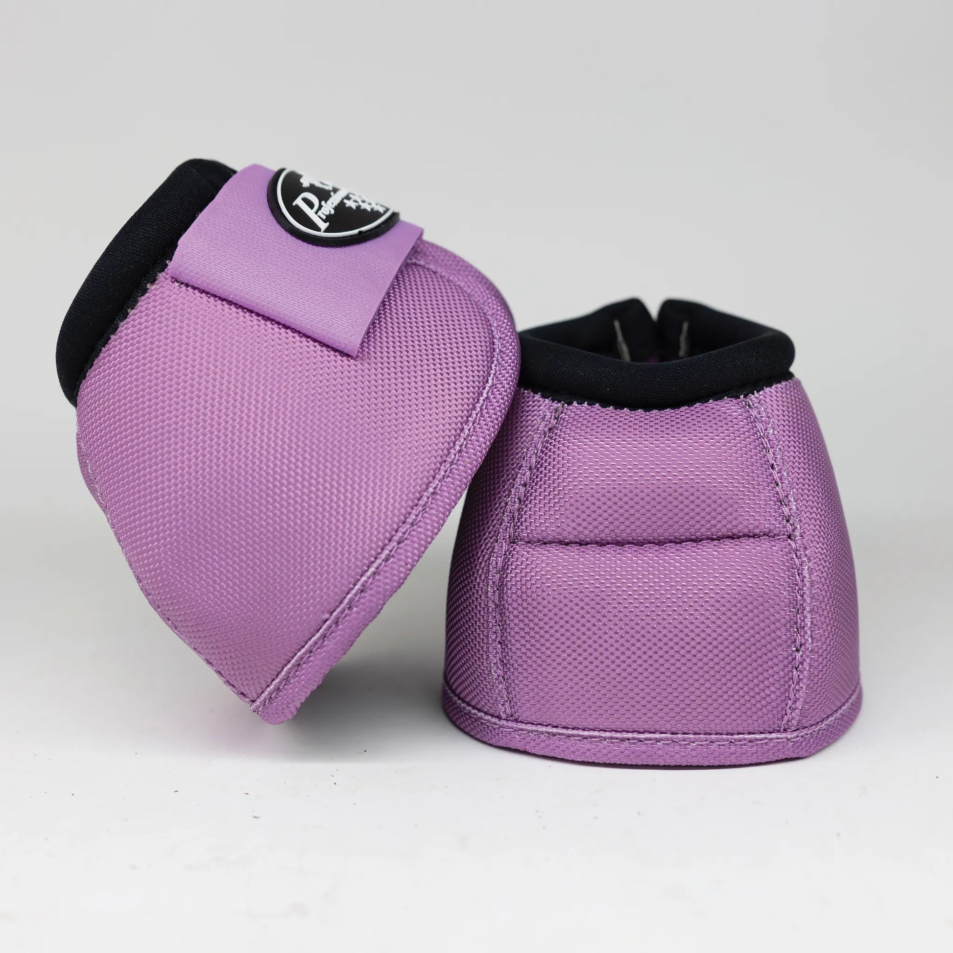 Professional’s Choice Ballistic Bell Boots in vibrant purple. High-performance horse hoof protection featuring a durable ballistic nylon exterior and padded black rims. These stylish lavender equestrian boots include a secure hook-and-loop closure with the brand logo, offering maximum impact protection and overreach defense for performance horses.