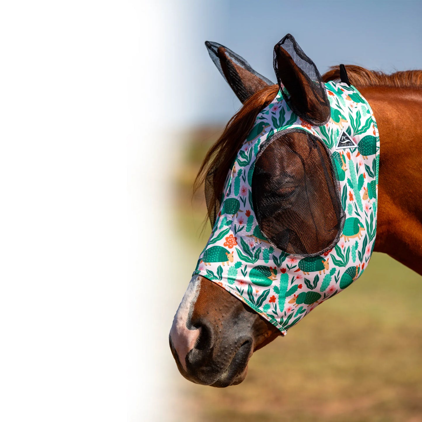 Professional's Choice Comfort-Fit Fly Mask featuring a whimsical desert armadillo and cactus print. This high-quality horse fly mask offers ultimate protection with breathable black mesh over the eyes and ears. The smooth, stretchy fabric ensures a secure and comfortable fit, preventing irritation from flies and UV rays. A stylish and functional choice for equine pest control and pasture comfort.