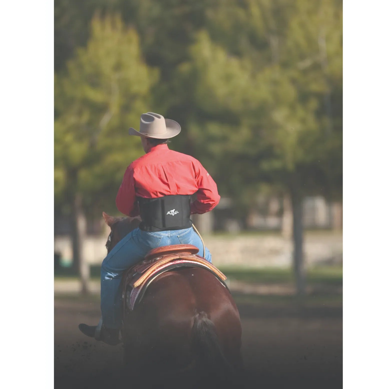 Professional’s Choice Comfort Fit Low Back Support in black, designed for equestrian comfort and stability. A cowboy wears the lumbar support belt while riding a brown horse, showcasing its secure fit over western attire. Perfect for horseback riders needing posture support and pain relief during long hours in the saddle or while working on the ranch.