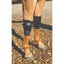 Professional’s Choice Equine Knee Boots in black, designed for superior leg protection. These durable neoprene knee boots for horses feature secure hook-and-loop closures and a contoured design to prevent slipping. Essential horse protective gear for injury prevention during training or trailering, shown on a chestnut horse's front legs in an outdoor setting.