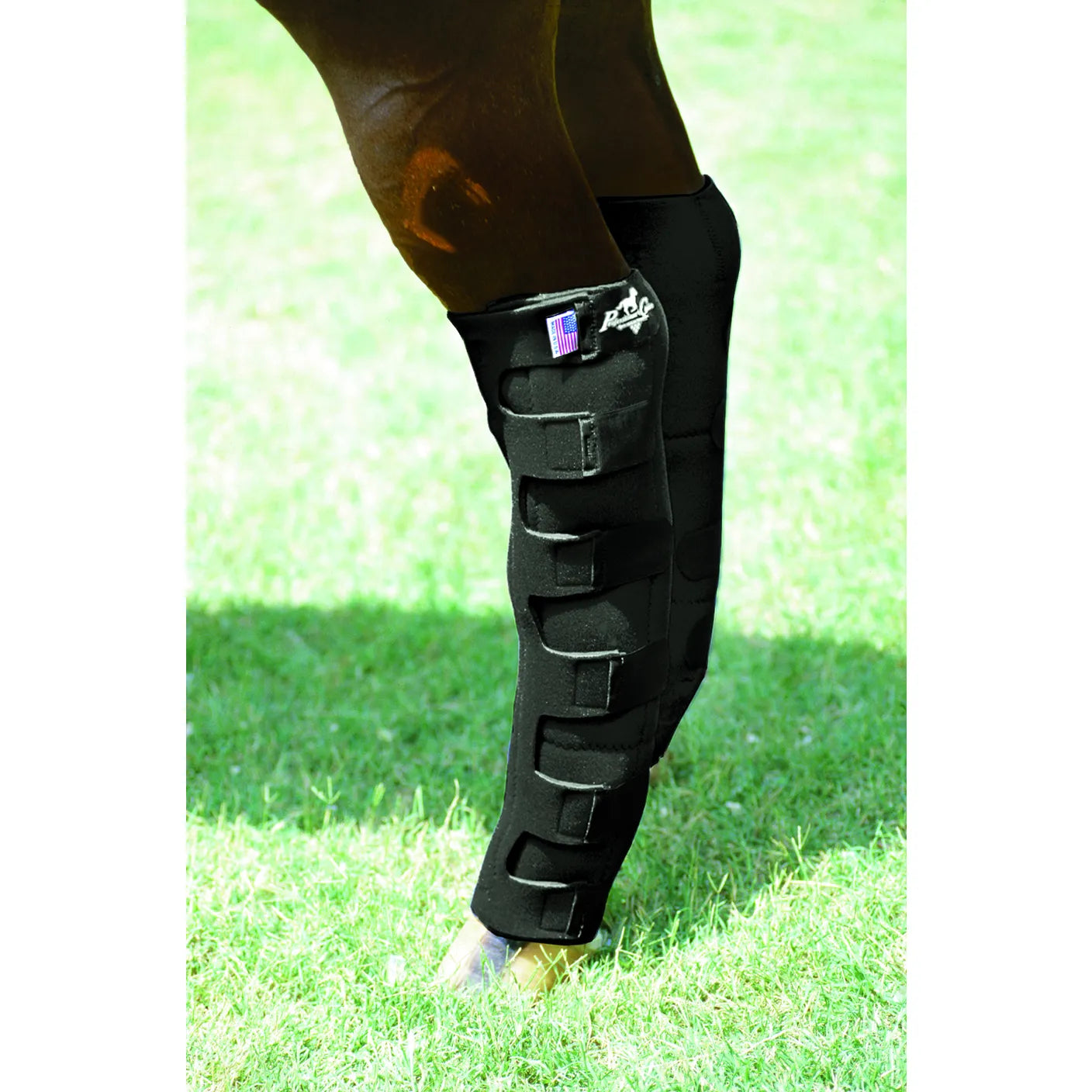 Black Professionals Choice Nine Pocket Ice Boots secured on a horse's leg for cooling therapy. These tall equestrian ice boots feature nine individual pockets to hold ice and multiple adjustable hook-and-loop straps for a customized, snug fit from hock to fetlock. Essential equine leg care for reducing heat and inflammation after exercise. Includes a small American flag patch and the Professional's Choice logo.