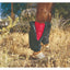Professional’s Choice SMB Covers in black, designed to protect horse boots from mud, burrs, and debris. One cover is partially open to reveal a bright red Sports Medicine Boot underneath, while the background leg shows the cover fully zipped. These durable nylon guards feature elastic ends, making them essential equestrian gear for keeping protective boots clean and dry during trail rides or turnout.
