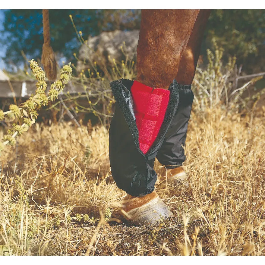 Professional’s Choice SMB Covers in black, designed to protect horse boots from mud, burrs, and debris. One cover is partially open to reveal a bright red Sports Medicine Boot underneath, while the background leg shows the cover fully zipped. These durable nylon guards feature elastic ends, making them essential equestrian gear for keeping protective boots clean and dry during trail rides or turnout.