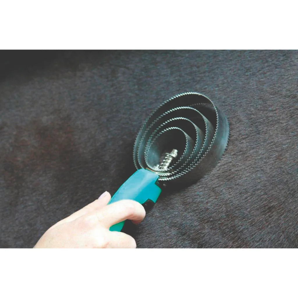 Professionals Choice Soft Touch Round Curry comb with a vibrant teal handle being used on a dark horse. This essential horse grooming tool features multiple concentric rings of serrated metal teeth designed for efficient shedding and removing mud. The ergonomic soft-grip handle provides comfort for daily equestrian care. A must-have horse brush for your grooming kit to keep coats healthy and clean.