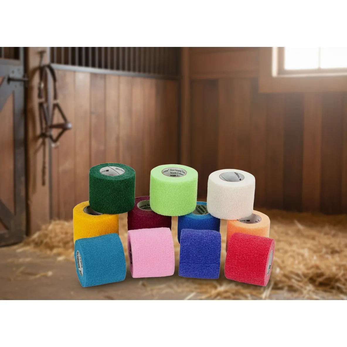 3M Vetrap Self-Adherent Bandage Tape in a vibrant assortment of colors like teal, pink, and lime green. These 2-inch x 5-yard breathable equine wraps are shown in a rustic barn setting, ideal for horse first aid, medical support, and equestrian care. This versatile cohesive tape sticks only to itself, making it a must-have for every stable’s first aid kit.