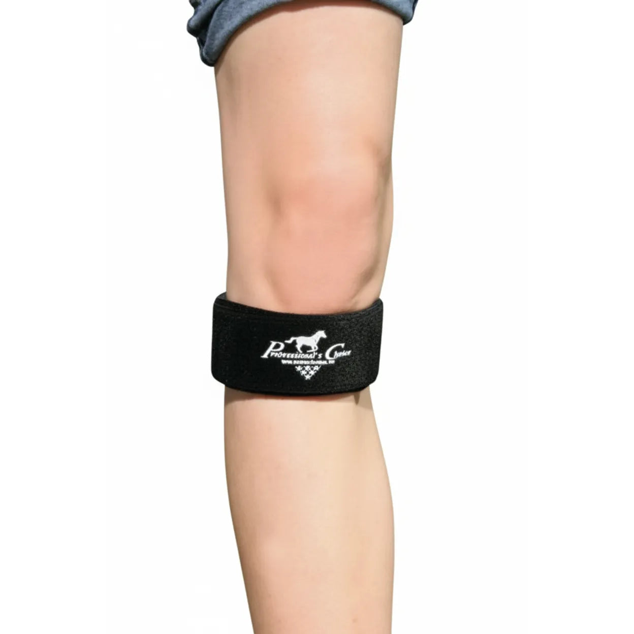 Black Professional's Choice knee compression strap wrapped securely below the patella on a leg. Designed for targeted pain relief from patella tendonitis and jumper's knee, this adjustable athletic support band features a white horse logo. Perfect for runners and athletes, it provides stability and pressure to reduce knee joint strain and discomfort during high-impact sports and exercise.