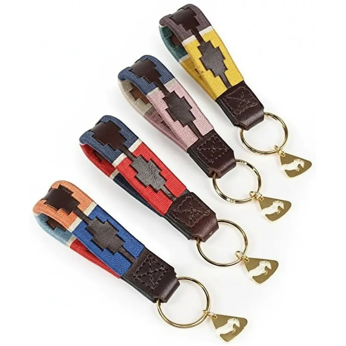 Shires Aubrion Polo Keyrings featuring premium 100% leather loops with traditional multi-colored pampa cross embroidery. This set of four equestrian accessories showcases vibrant patterns in red, navy, pink, and yellow. Each keychain is finished with a gold-tone split ring and a signature horse-shaped charm. A stylish and durable gift for horse lovers, these keyrings bring classic polo fashion to everyday essentials.