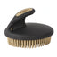 Weaver Leather Palm Curry Comb featuring an ergonomic black handle with a tan logo inlay and durable tan flexible bristles. This high-quality horse grooming tool is designed to reduce hand fatigue while efficiently cleaning and massaging a horse's coat. The oval design and comfortable grip make it an essential addition to any grooming kit for daily care, mud removal, or bathing.
