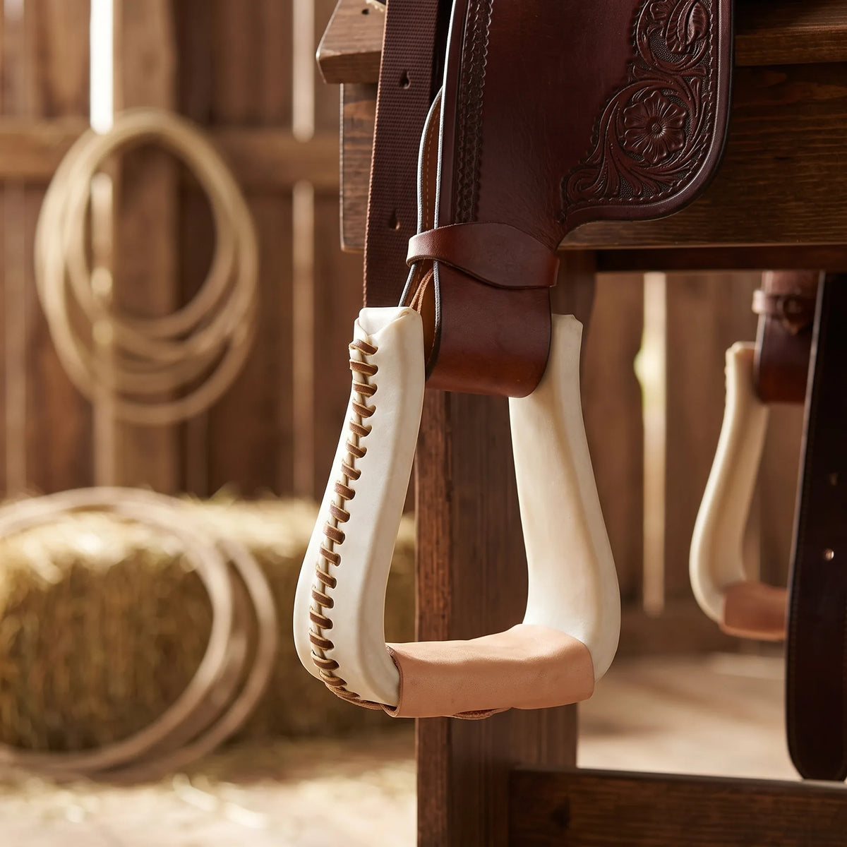 Weaver Leather rawhide covered roper stirrup hanging from a western saddle fender